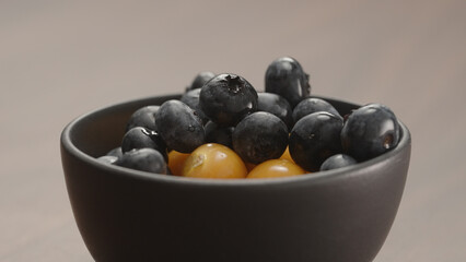 blueberries in black bowl with physalis closeup