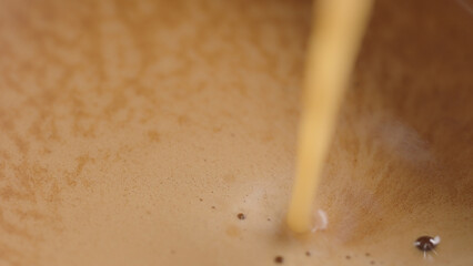espresso pour into white cup closeup