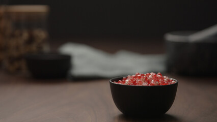 pomegranate seeds in black bowl