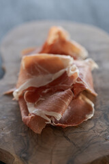 Thin slices of jamon on olive wood board