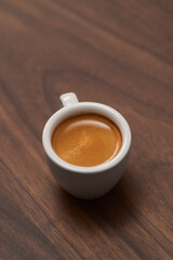 Cup of fresh espresso in white cup on walnut table with copy space