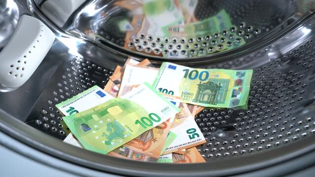 Euro money banknotes in washing machine - illegal cash 50, 100 €  and mafia money laundering - tax evasion in Europe inflation and impairment