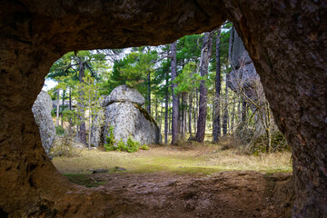 Rocky cave framing the forest of the Enchanted City of Cuenca Spain.