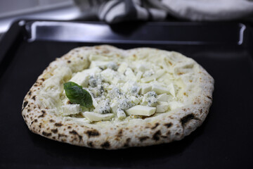Frozen semi-cooked Neapolitan pizza on a baking sheet