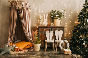 The stylish interior of the children's room with wooden furniture and a rustic wigwam is decorated for Christmas © ksyusha_yanovich