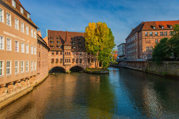 Ancient Nurnberg Heilig Geist Spital building over Pegnitz river. View from the Bridge on the River Pegnitz. Hospital of the Holy Ghost. Nuremberg, Germany.