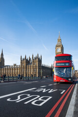 Fototapeta na wymiar Historic and Iconic Westminster palace and 2022 revealed Big Ben after restoration works with London red bus driving by