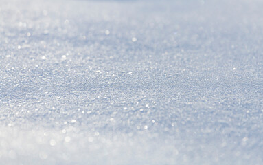 Obraz premium Close up macro photography texture of sparkling fresh white snow with light blue sky reflection tone. Selective focus. Winter christmas background.