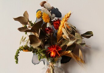 dried flowers of different colors in a glass vase