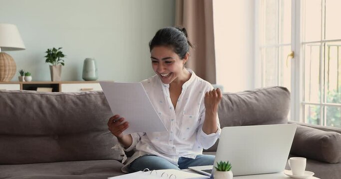 Overjoyed Indian woman read good fantastic news in paper letter, got bank notice about loan approval, celebrates business or personal success. Achievement, new job opportunity, taxes refund concept