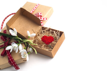 red heart in a box, a bouquet of snowdrops on a white background