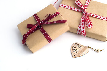 two gift boxes, a wooden heart on a white background.