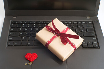 gift box tied with ribbon on laptop.congratulations on March 8, mother's day, birthday. romantic background. 