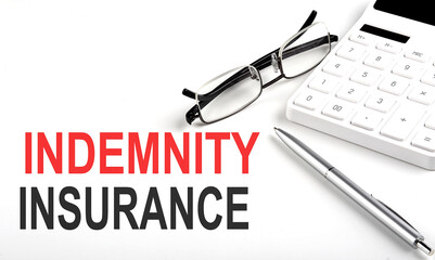 INDEMNITY INSURANCE Concept. Calculator,pen and glasses on white background