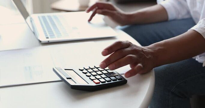 Close up cropped view woman paying bills on-line use computer, manage household finance or taxes use calculator, controlling family expenditures, makes payment through e-bank, Savings, finance concept