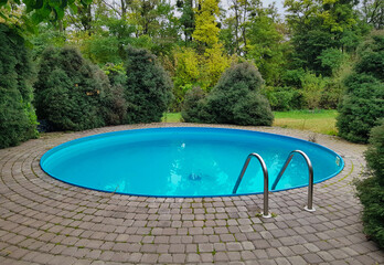 small round home outdoor swimming pool on the plot and overlooking the forest, blue pool, forest...
