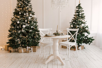 Stylish bright interior of the living room with a Christmas tree and a festive table