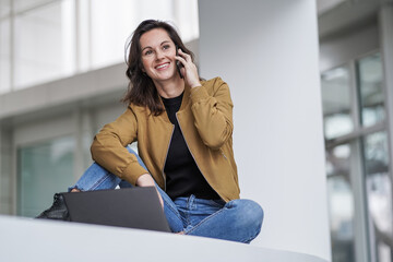 smiling  easygoing remote working lady girl calling and chatting infront of a laptop or notebook in...