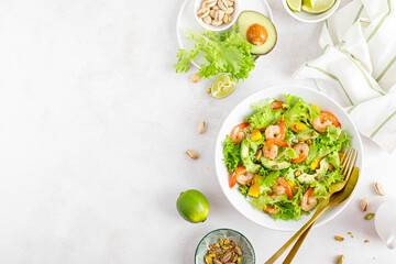 Grilled shrimp salad with avocado, mango, lettuce and pistachios, dressed with lime. Healthy food. Ketogenic diet. Top view.