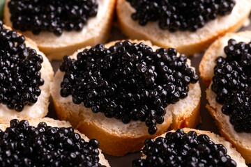 Slices of bread with black caviar on plate