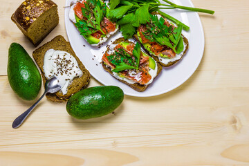 Sandwiches with avocado, trout and sour cream, sprinkled with spicy dill. Celery leaves.