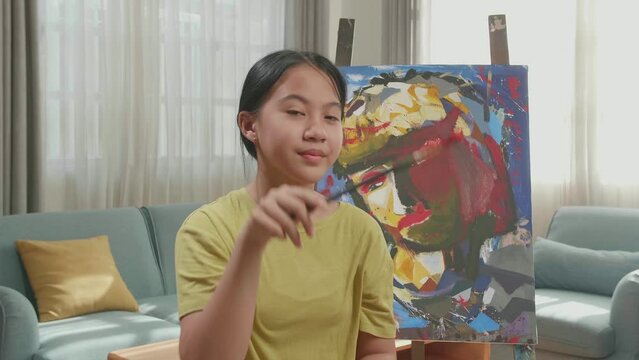 Asian Artist Girl Holding Paintbrush Wipe The Sweat Before Crossing His Arms And Smiling After Finish Painting On The Canvas
