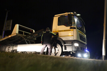 Samochód pomocy drogowej podczas obsługi wypadku drogowego w nocy na drodze.  - obrazy, fototapety, plakaty
