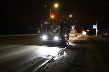 Samochód serwisu drogowego podczas obsługi wypadku drogowego w nocy na drodze. 