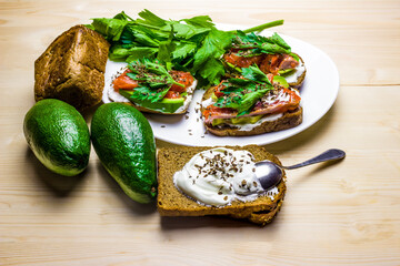 Sandwiches with avocado, trout and sour cream, sprinkled with spicy dill. Celery leaves.