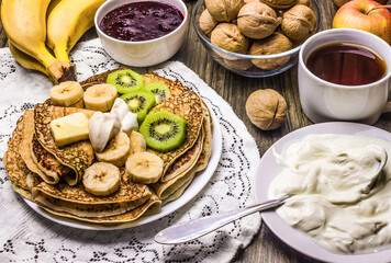 Russian pancakes with fruit and sour cream.