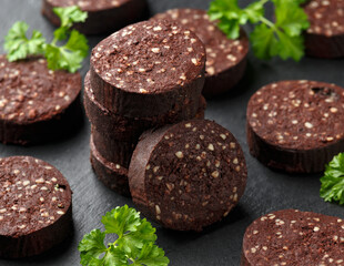 Raw Black Pudding with parsley on rustic stone board