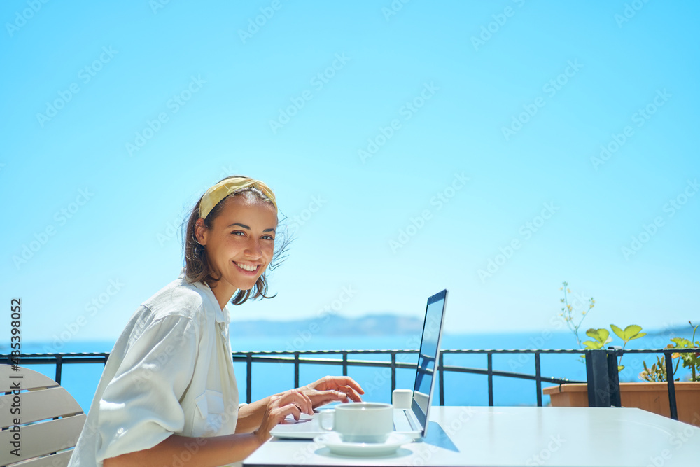 Wall mural beautiful young mixed race woman smiling to camera enjoying using laptop online internet at outdoor 