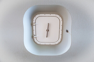 Closed marine watertight iron door on a white ship hull, close-up.