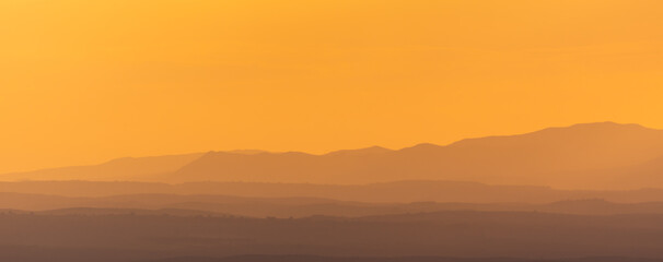 Top view of a reservoir with calm waters reflecting a sunset between clouds in Andalucia (Spain)