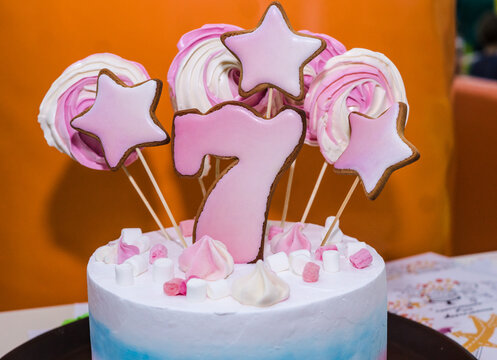 beautiful cake in pink and white colors for the birthday or with the number seseven, gingerbread stars and marshmallow