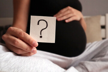 Pregnant woman holding cards with the inscription who there