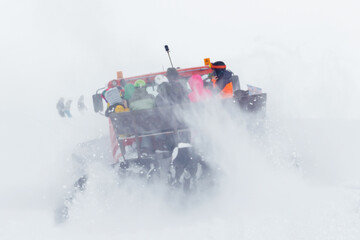 People in the back of a snowcat are driving along a snowy road. Soft focus. ..