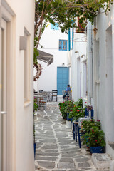 Paros island cafe tavern at Naousa Greece. Cyclades architecture, cobblestone alley. Vertical
