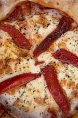Pizza background. Closeup view of a pizza with mozzarella cheese and roasted red bell pepper slices.