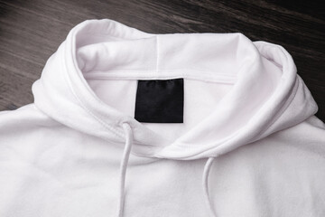 Empty black label on white sweatshirt for logo, size and info.