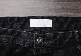 Blank clothing label on denim jeans texture. Label with empty space for text