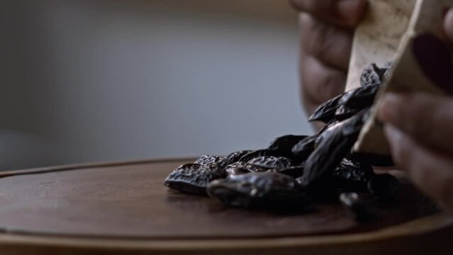 Pouring out a bowl of cumaru seeds or tonka beans harvested organically in the Amazon rainforest - slow motion