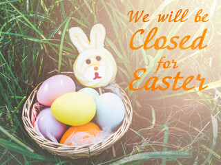 Signboard with the inscription We will be closed for Easter. Easter eggs painted with colorful paints. Closeup, indoors, no people. Congratulations for loved ones, relatives, friends, colleagues