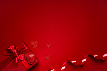 Red box with red ribbon, hearts on a red background, a romantic valentine's day gift for lovers.