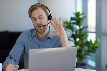 Caucasian man at home remote working at home on laptop computer talking to a colleague