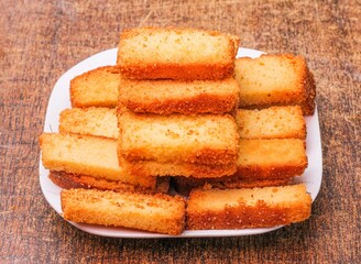 crispy cake rusk in a plate isolated on dark wooden background top view