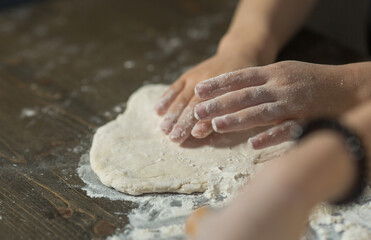 children's hands make dough on the table close-up.