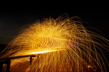 Image playing fireworks by rotating the wave shape of the lines, sparks to light. Amazing Fire Dance in the middle basin slope and beautiful reflection with copy space