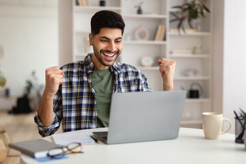 Obraz premium Arabic man using laptop celebrating success shaking fists screaming yes