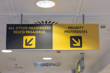 Priority and others passengers sign in english and spanish.